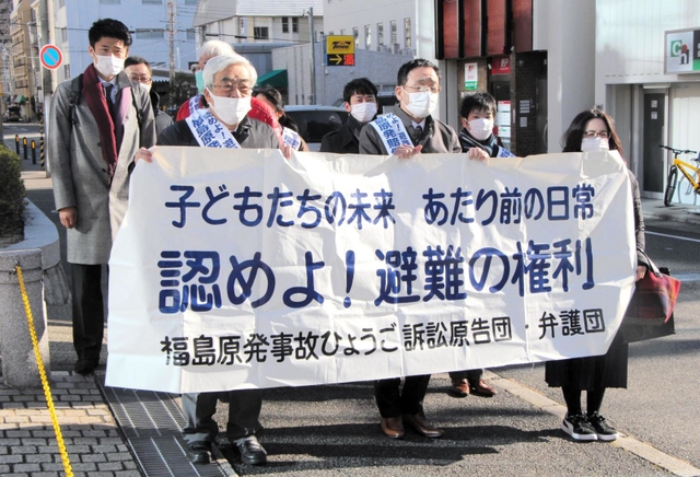 本人尋問を前に、神戸地裁前で横断幕を掲げる原告団＝２０日午前、神戸市中央区橘通２