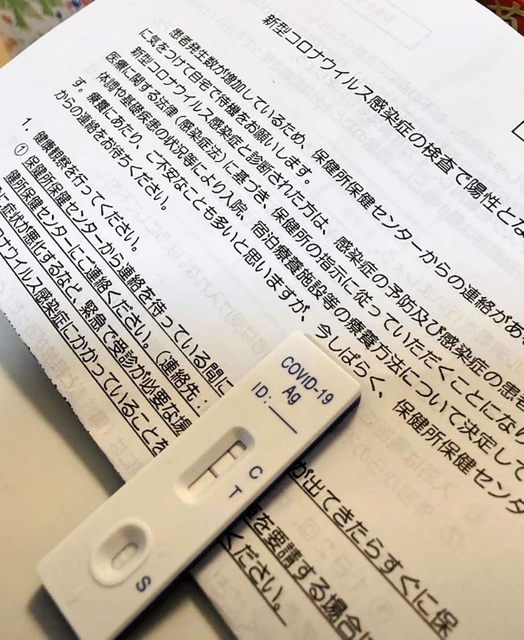 母親の新型コロナ陽性を知らせる抗原検査キットと陽性者への注意事項を伝える文書＝神戸市内（提供写真）