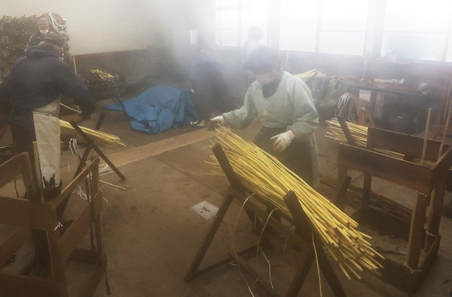 蒸したコウゾの皮をはぎ、川さらしの準備をする人々＝多可町加美区鳥羽