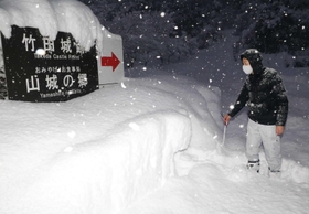 竹田城跡の麓で積雪量を確認する朝来市観光交流課の杉浦康将主事＝２０２１年１２月２７日早朝、同市和田山町殿