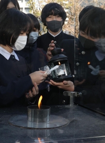 「１・１７希望の灯り」から火を移す参加者ら＝８日午後、神戸市中央区加納町６（撮影・小林良多）