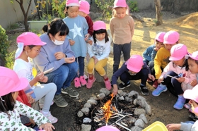 たき火をするニコニコ桜保育園の園児ら＝西宮市南郷町