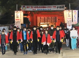 運営スタッフの先導でゆっくりと参道を歩く参拝者＝１０日午前６時ごろ、西宮神社