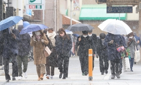 雪の中、身をちぢめて歩く人たち＝１２日午後、西宮市田中町（撮影・斎藤雅志）