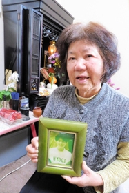 中学時代の娘の写真を手に話す大石博子さん＝神戸市兵庫区大開通