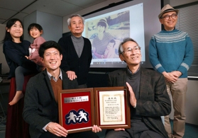 命の尊さを伝え続ける。母と弟の写真の前でそう誓う「語り部ＫＯＢＥ１９９５」代表の長谷川元気さん（前列左）と前代表の田村勝太郎さん（同右）ら＝神戸市中央区東川崎町１、ひょうごボランタリープラザ（撮影・吉田敦史）