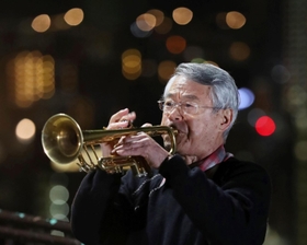 追悼の思いを込め、神戸の街へ高らかに音色を響かせる松平晃さん＝１７日午前５時５２分、ビーナスブリッジ（撮影・大森　武）