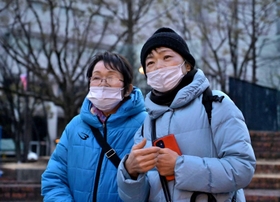 三女の湯口典子さん一家３人を亡くした天畠ヒサコさん（左）。長女の玲子さんと訪れた＝１７日午前７時２１分、神戸市中央区加納町６、東遊園地（撮影・秋山亮太）