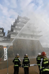 国宝・世界遺産姫路城の大天守に向かって放水する消防隊員＝２６日午前、姫路市本町（撮影・大山伸一郎）