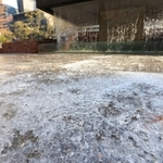 厳しい冷え込みで凍結した水たまり＝１４日午前、神戸市中央区加納町６、東遊園地