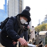 竹灯籠に火をともす高橋一子さん＝１７日午後０時５９分、神戸市中央区加納町６、東遊園地（撮影・鈴木雅之）