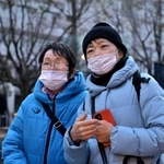 三女の湯口典子さん一家３人を亡くした天畠ヒサコさん（左）。長女の玲子さんと訪れた＝１７日午前７時２１分、神戸市中央区加納町６、東遊園地（撮影・秋山亮太）
