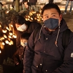 亡くなった祖父の慰霊のため東遊園地を訪れた大前敏郎さん（右）。竹灯ろうに明かりをともしながら長男に祖父のことを話して聞かせた＝１７日午後、神戸市中央区加納町６（撮影・小林良多）