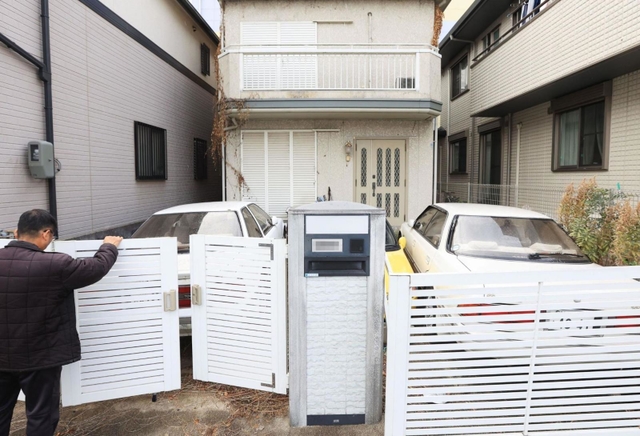 住むはずだった自宅の前に立つ男性。玄関前に使っていない車を置いている＝神戸市灘区（撮影・吉田敦史、画像の一部を加工しています）