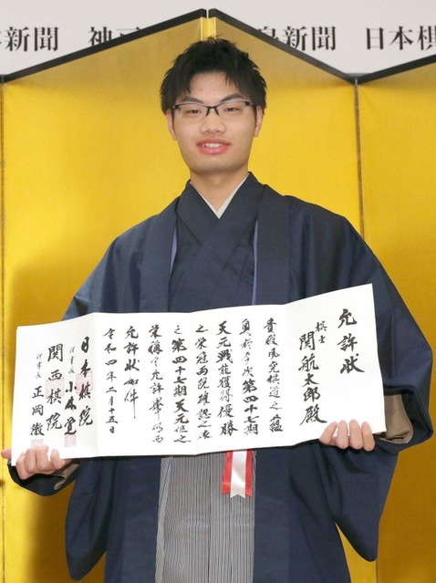 允許状を手に笑顔を見せる関航太郎天元＝１５日午後、東京都千代田区