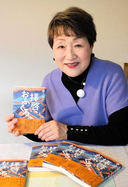 病床の道上洋三さんをサポートし、完成させた著書を手に出版を喜ぶ妻の暸子さん＝伊丹市内