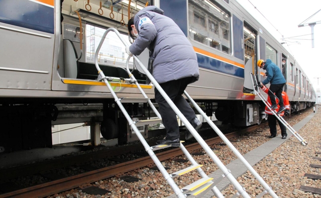 鉄道車両に避難はしごを設置するＪＲ西日本神戸支社の社員ら＝２２日午前、ＪＲ兵庫駅