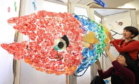 「プラごみすいぞくかん」と題したオブジェを制作するマキコムズの２人＝神戸市長田区二葉町７、ふたば学舎