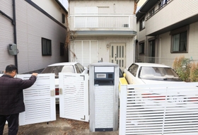 住むはずだった自宅の前に立つ男性。玄関前に使っていない車を置いている＝神戸市灘区（撮影・吉田敦史、画像の一部を加工しています）