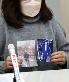 高橋さんの写真を手に会見に臨む女性＝２２日午後、神戸市中央区