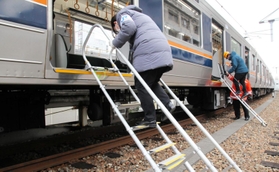 鉄道車両に避難はしごを設置するＪＲ西日本神戸支社の社員ら＝２２日午前、ＪＲ兵庫駅
