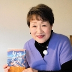 病床の道上洋三さんをサポートし、完成させた著書を手に出版を喜ぶ妻の暸子さん＝伊丹市内