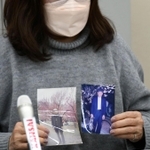 高橋さんの写真を手に会見に臨む女性＝２２日午後、神戸市中央区