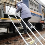 鉄道車両に避難はしごを設置するＪＲ西日本神戸支社の社員ら＝２２日午前、ＪＲ兵庫駅