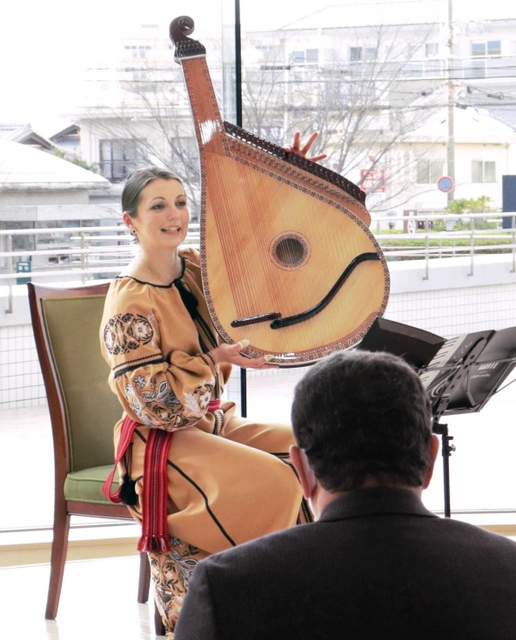 ウクライナの民族楽器バンドゥーラを紹介するカテリーナさん＝１月１２日、神戸市西区伊川谷町有瀬、神戸学院大学有瀬キャンパス