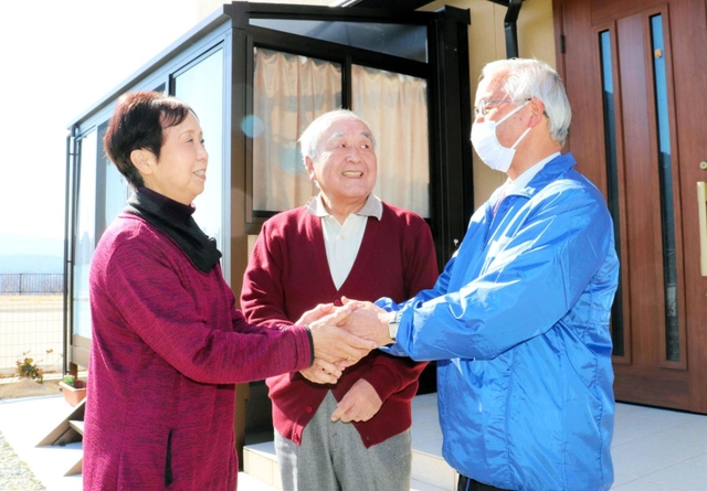 再建した自宅前で、高橋守雄所長（右）と再会した佐藤清太郎さん、京子さん夫婦＝１０日午後、宮城県南三陸町志津川
