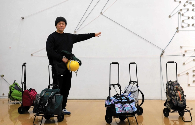 観客が美術館の外へ運び出す作品「デコレータークラブ－ベリーヘビーバッグ」（２０２２年）を並べた飯川雄大さん＝兵庫県立美術館