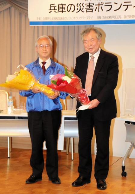 花束を受け取った室崎益輝教授（右）と高橋守雄所長＝神戸市中央区東川崎町１