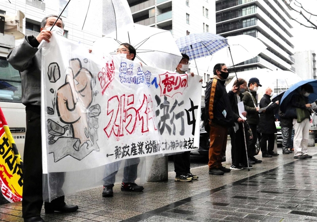 待遇改善を求めてストライキを実施した郵政産業労働者ユニオンの組合員ら＝神戸市中央区栄町通６