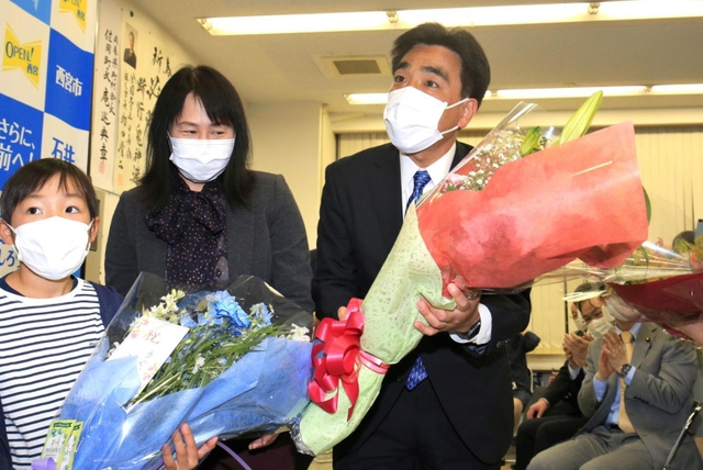 再選を確実にし、支援者から贈られた花束を手に喜ぶ石井登志郎氏＝２７日午後８時２９分、西宮市上甲子園４（撮影・斎藤雅志）
