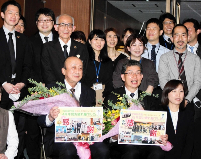 職員たちに囲まれて記念撮影する和田満副市長（前列左）と宮脇俊夫副市長＝明石市役所