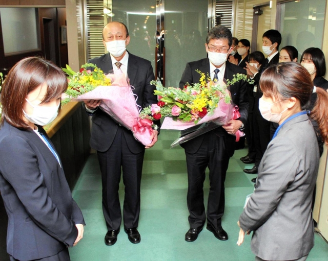 職員から花束を贈られる和田満副市長（中央左）と宮脇俊夫副市長＝明石市役所
