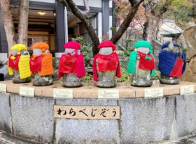 ６色の帽子とマント姿に変身した「わらべじぞう」＝神戸市須磨区