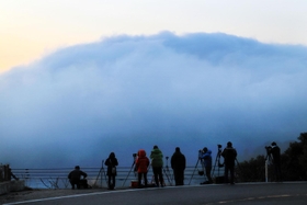 山のように盛り上がった霧が海に向かって流れ込む＝４日午前６時３５分、豊岡市瀬戸（撮影・岡本好太郎）