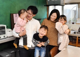 竹野海岸の近くでゲストハウスをオープンした権赫讃さん（左から２人目）と家族＝豊岡市竹野町竹野