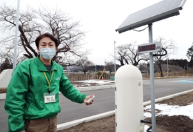 ＪＲ夜ノ森駅前で線量計を手にするガイドの里見喜生さん＝福島県富岡町