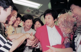 当選を決め、支持者に握手攻めにされる北村春江さん（右から２人目）＝１９９５年６月１１日、芦屋市公光町