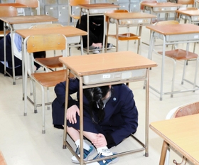 大掃除中に放送が流れ、その場で頭を守る生徒ら＝いずれも２２日、兵庫県立舞子高校