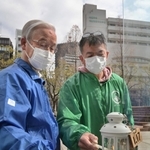 「１・１７希望の灯り」の火をランタンに移す杉山正秀代表（右）と高橋守雄所長＝神戸市中央区加納町６（撮影・秋山亮太）