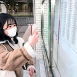 合格を確認し、張り出された番号を写真撮影する受験生＝７日午前、神戸市西区学園東町９、神戸市外国語大学（撮影・坂井萌香）