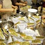 一斉避難訓練で非常食のアルファ化米で炊き出しの用意をする女性ら＝養父市内（資料写真）