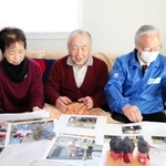 仮設住宅の写真などを前に再会を喜ぶ高橋守雄所長（右）と佐藤清太郎さん、妻京子さん＝宮城県南三陸町志津川