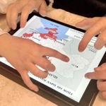 地図を見ながら、子どもたちにウクライナの家族や知人の状況を伝える男性＝兵庫県内