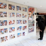 神戸国際松竹の玄関前で寅さんシリーズのポスターに見入る観客＝神戸市中央区御幸通８