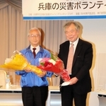 花束を受け取った室崎益輝教授（右）と高橋守雄所長＝神戸市中央区東川崎町１