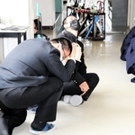 大掃除中に放送が流れ、その場で頭を守る生徒ら＝２２日、兵庫県立舞子高校